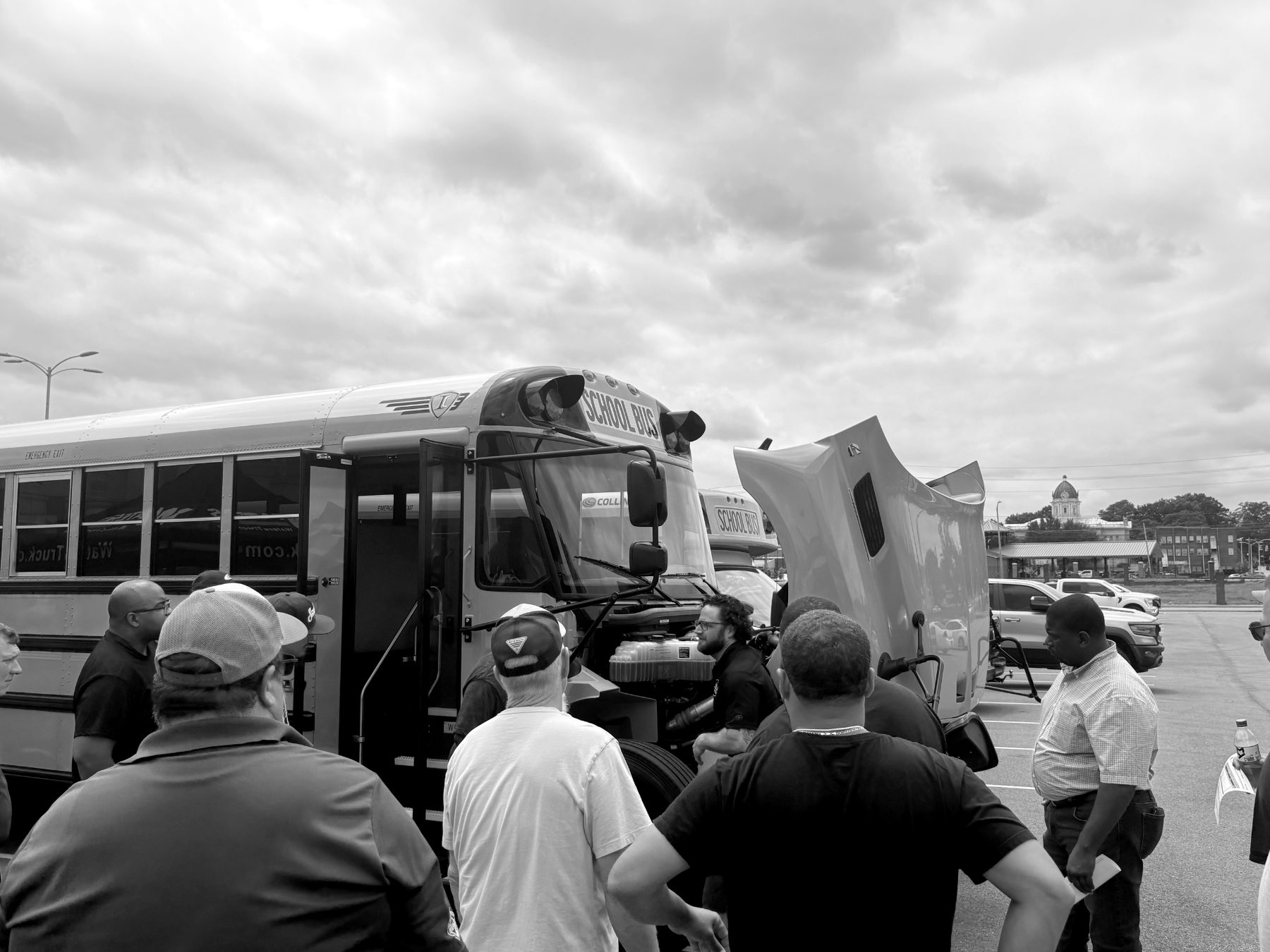 Technicians examining a school bus engine at the MAPT trade show